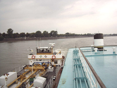 Neben Dach samt Schornstein des hohen Fahrgastschiffes wirkt das Steuerhaus des schleppenden Tankers sehr klein.