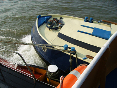 Draufsicht aufs geschleppte Boot von oben, neben dem Steuerhaus des Binnentankers.