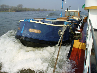 Nah dran, ist das kleine Boot gar nicht mehr klein neben der Schifferwohnung und hat eine mächtige Bugwelle.