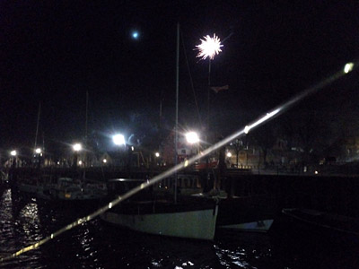 Boote im nächtlichen Hafen, Lichterkette quer durchs Bild