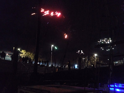 Viele Menschen-Silhozuetten auf der Treppe am Hafen, Rauch und Feuerwerklichter